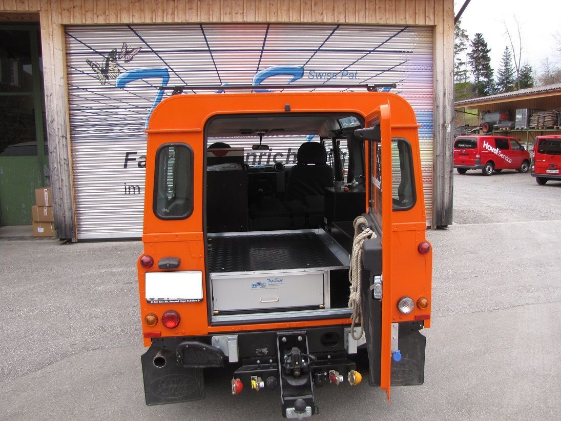 Ein orangefarbenes Fahrzeug steht vor einem Garagentor