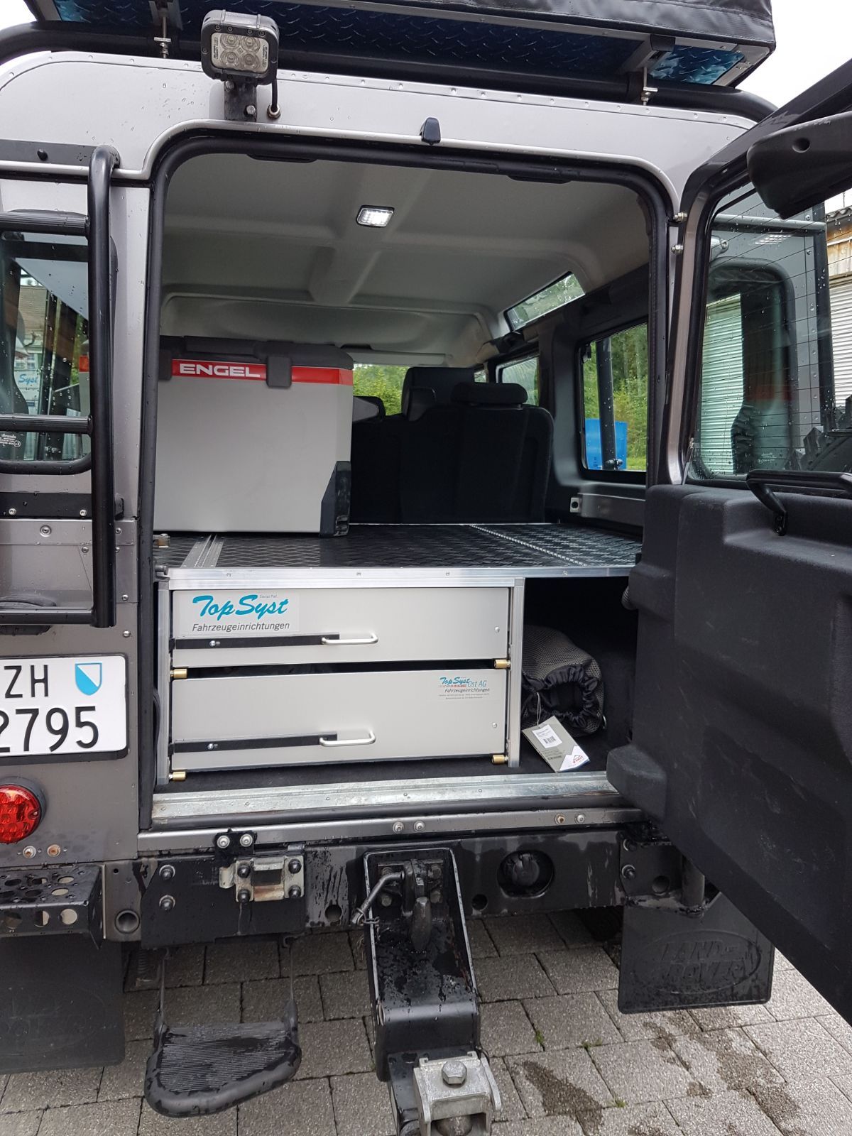 Die Rückseite eines Fahrzeugs mit offener Tür und einem Nummernschild mit der Aufschrift zh 2795