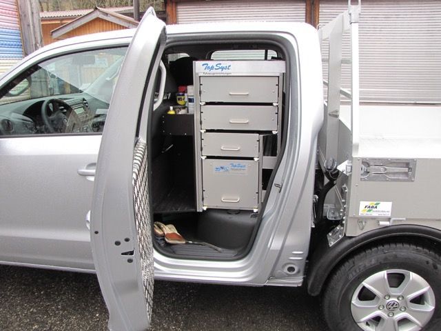 Ein silberner Truck mit offener Tür und Schubladen im Heck