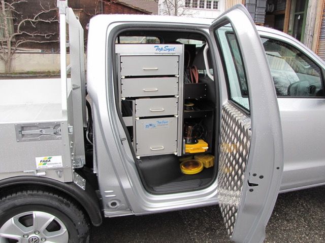 Ein silberner Truck mit offener Tür und Schubladen im Heck