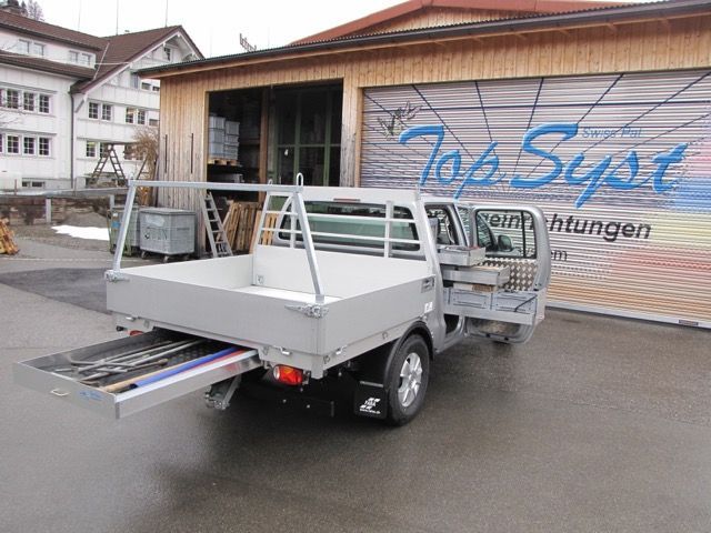 Ein LKW steht vor einem Gebäude mit der Aufschrift „Top Syst“