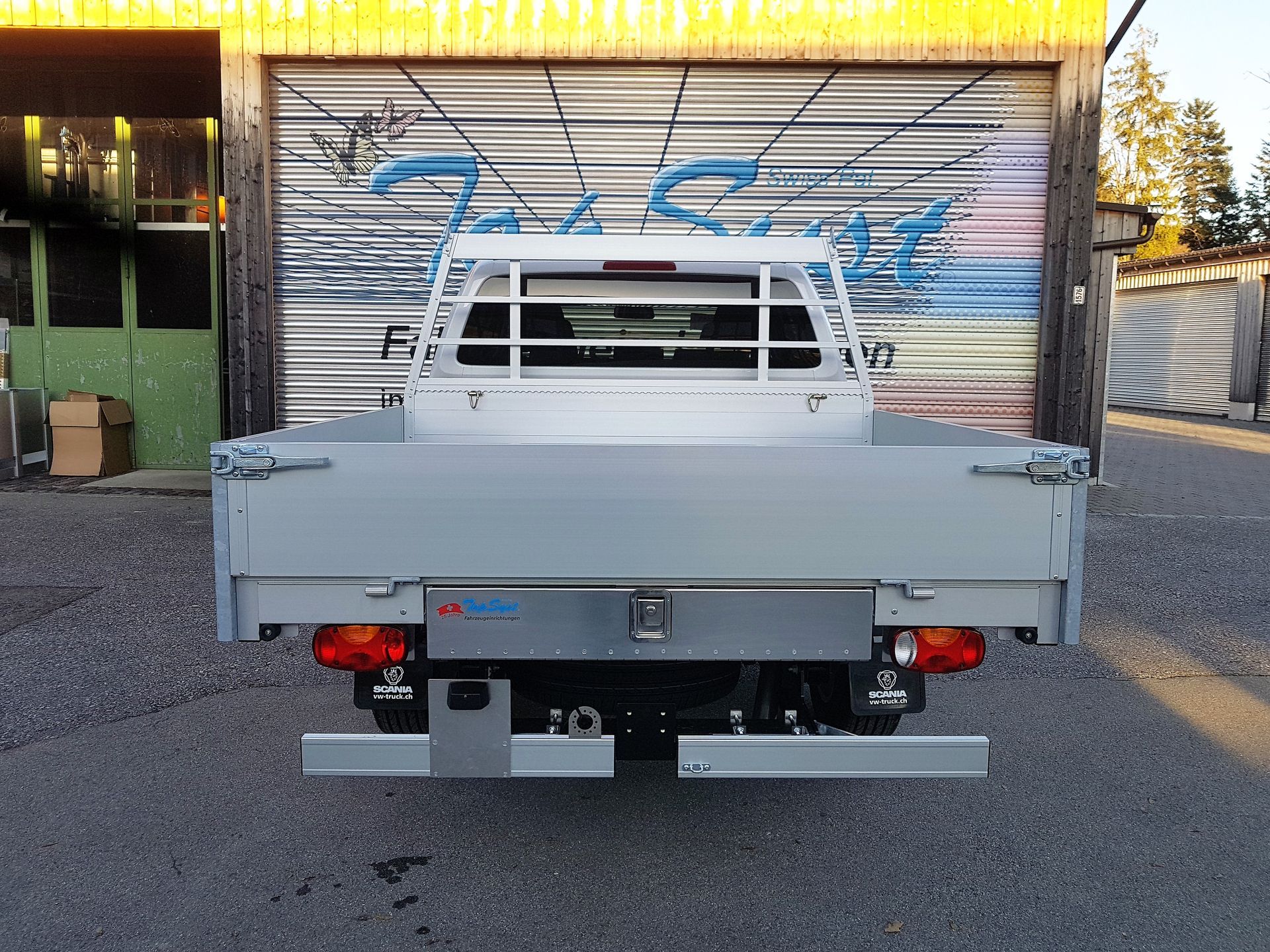 Ein LKW steht vor einer Garage mit Graffiti darauf
