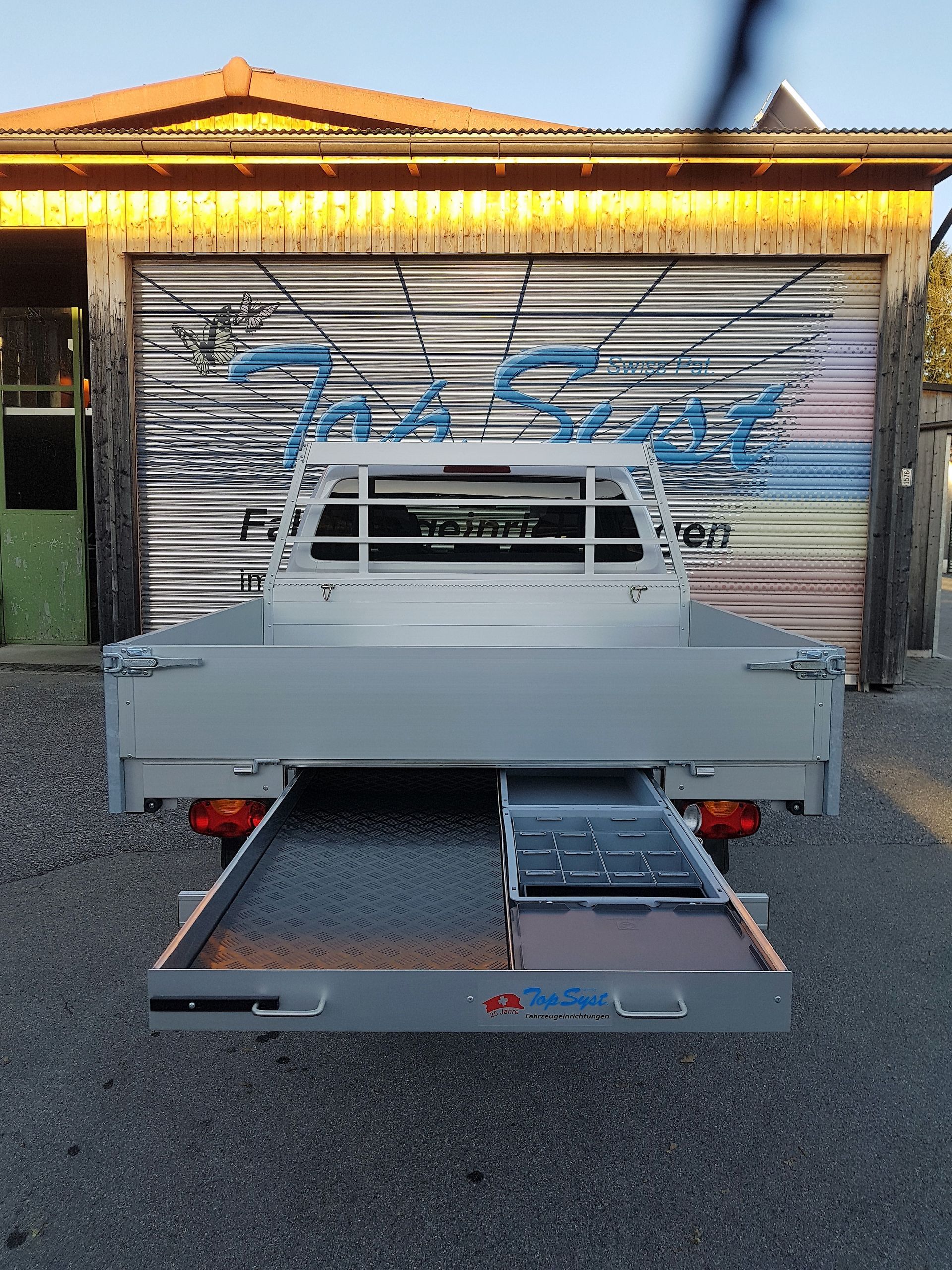 Ein LKW steht vor einer Garage mit Graffiti darauf