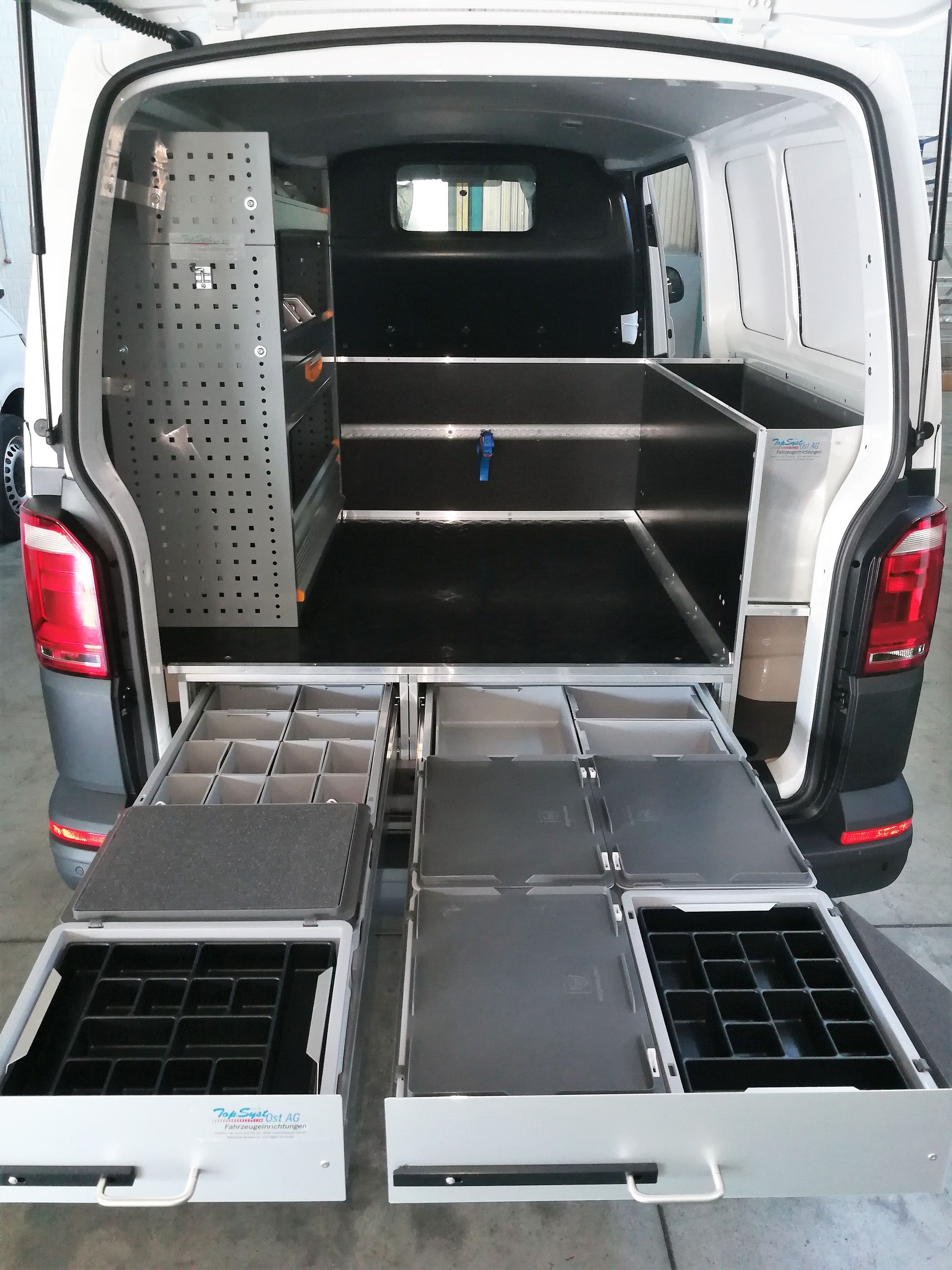 Der hintere Teil eines Lieferwagens mit Schubladen und Regalen.