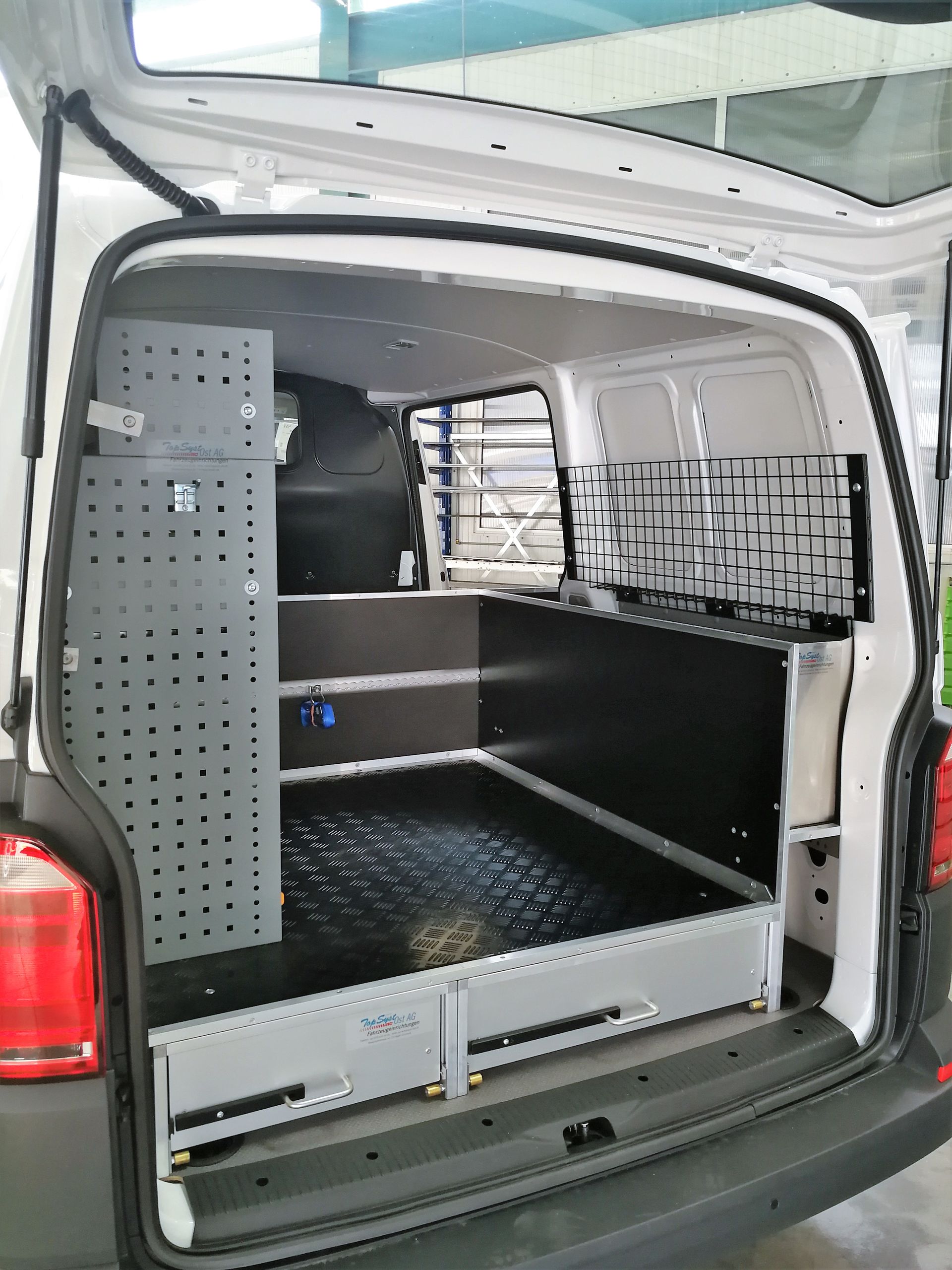 Die Rückseite eines weißen Lieferwagens mit offener Tür.
