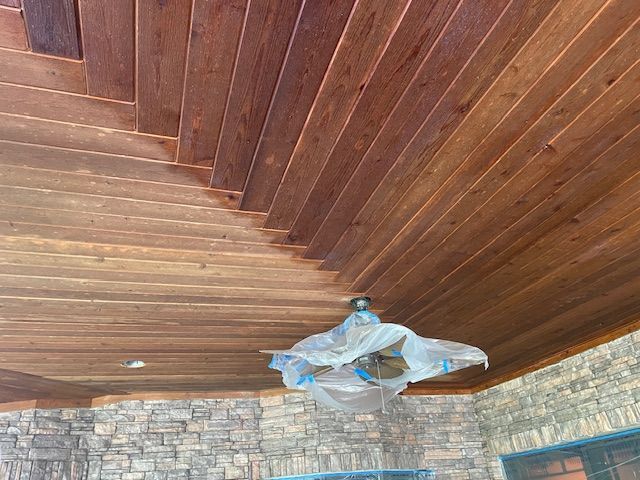 A wooden ceiling with a ceiling fan hanging from it.