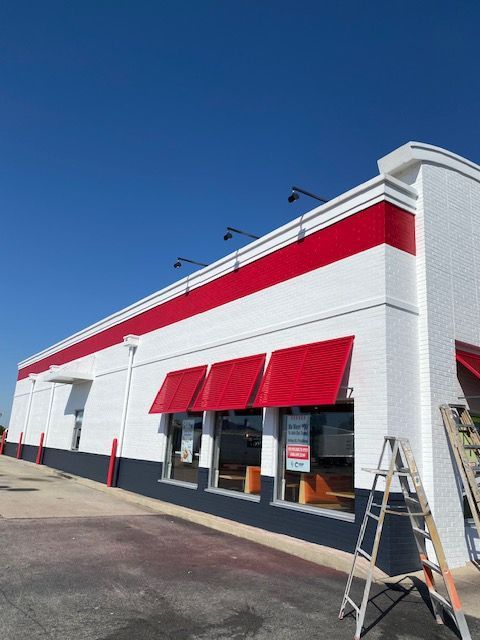 A white building with red awnings on the windows