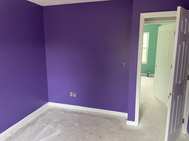 A room with purple walls and a door that is open.