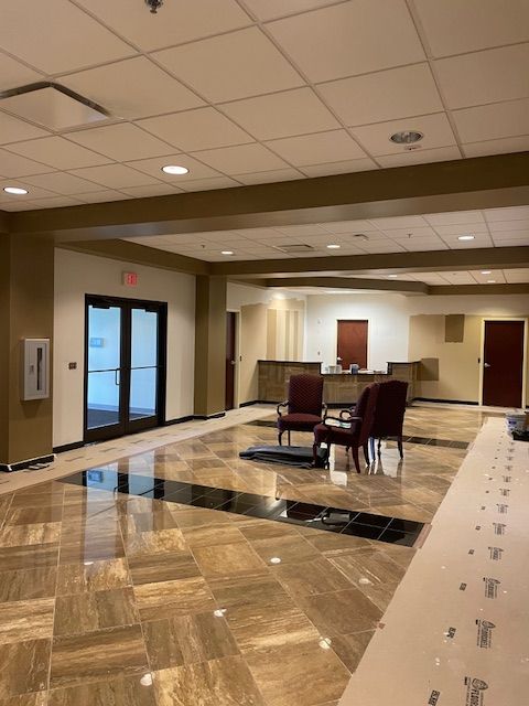 A large room with a marble floor and chairs
