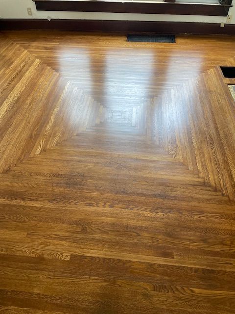 A living room with a wooden floor and a fireplace.