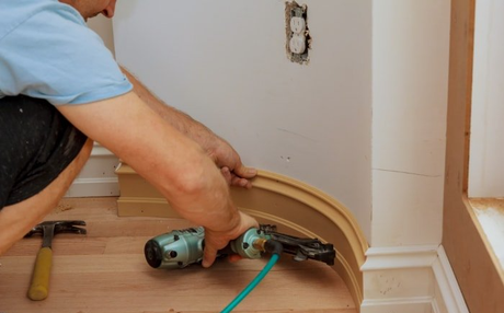 residential home carpenter installing trimming/molding on residential home edges.