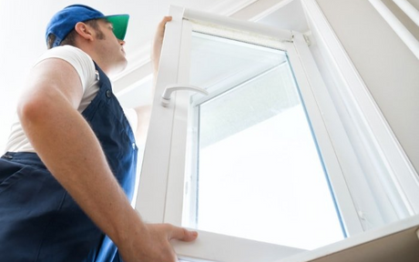 handyman carpenter installing new all white window in residential home