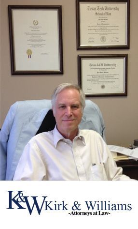 A man in a white shirt is sitting in a chair in front of three framed diplomas ..