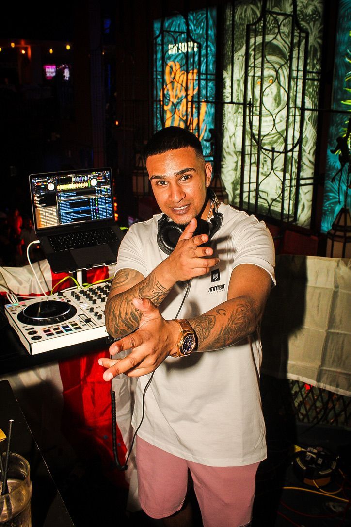 A man is standing in front of a dj controller.