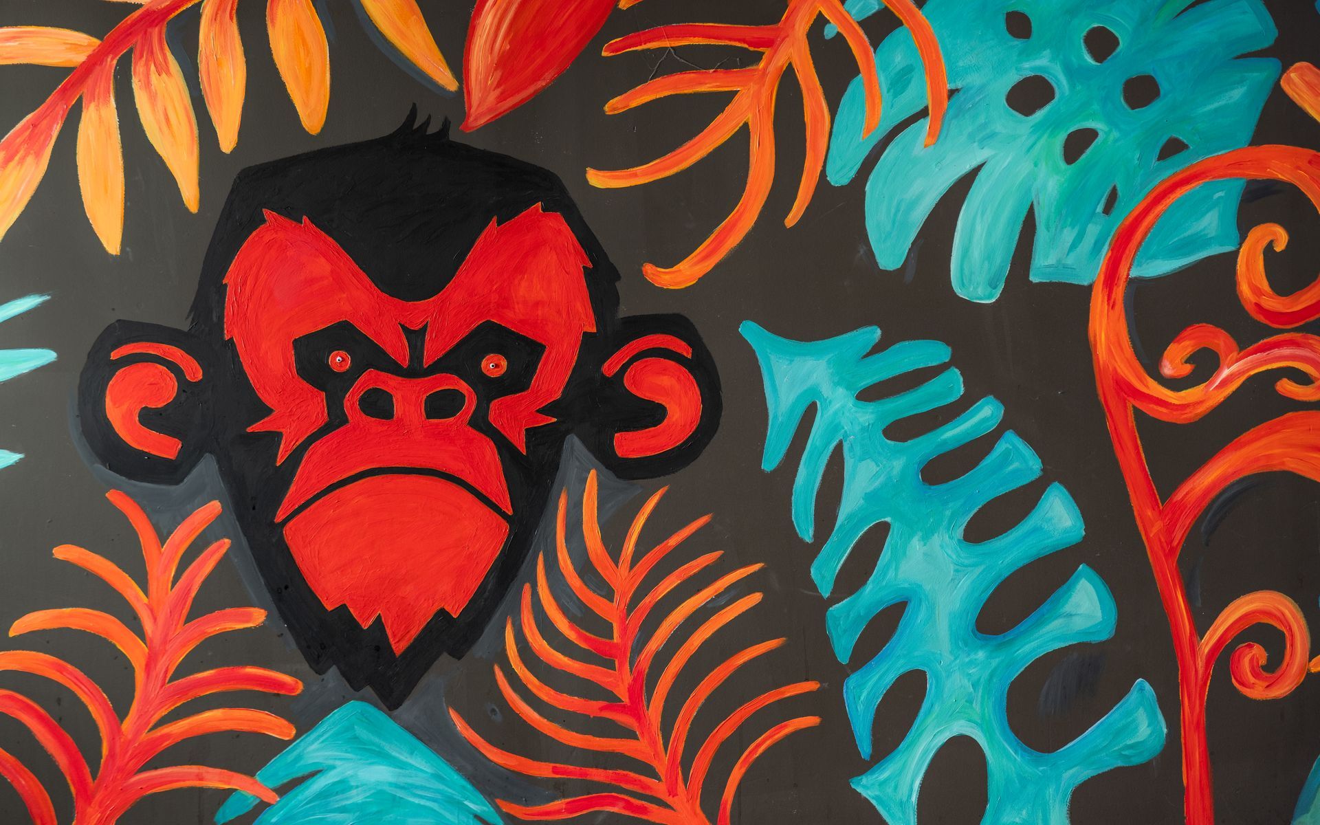 A painting of a monkey with a heart on its face surrounded by leaves.