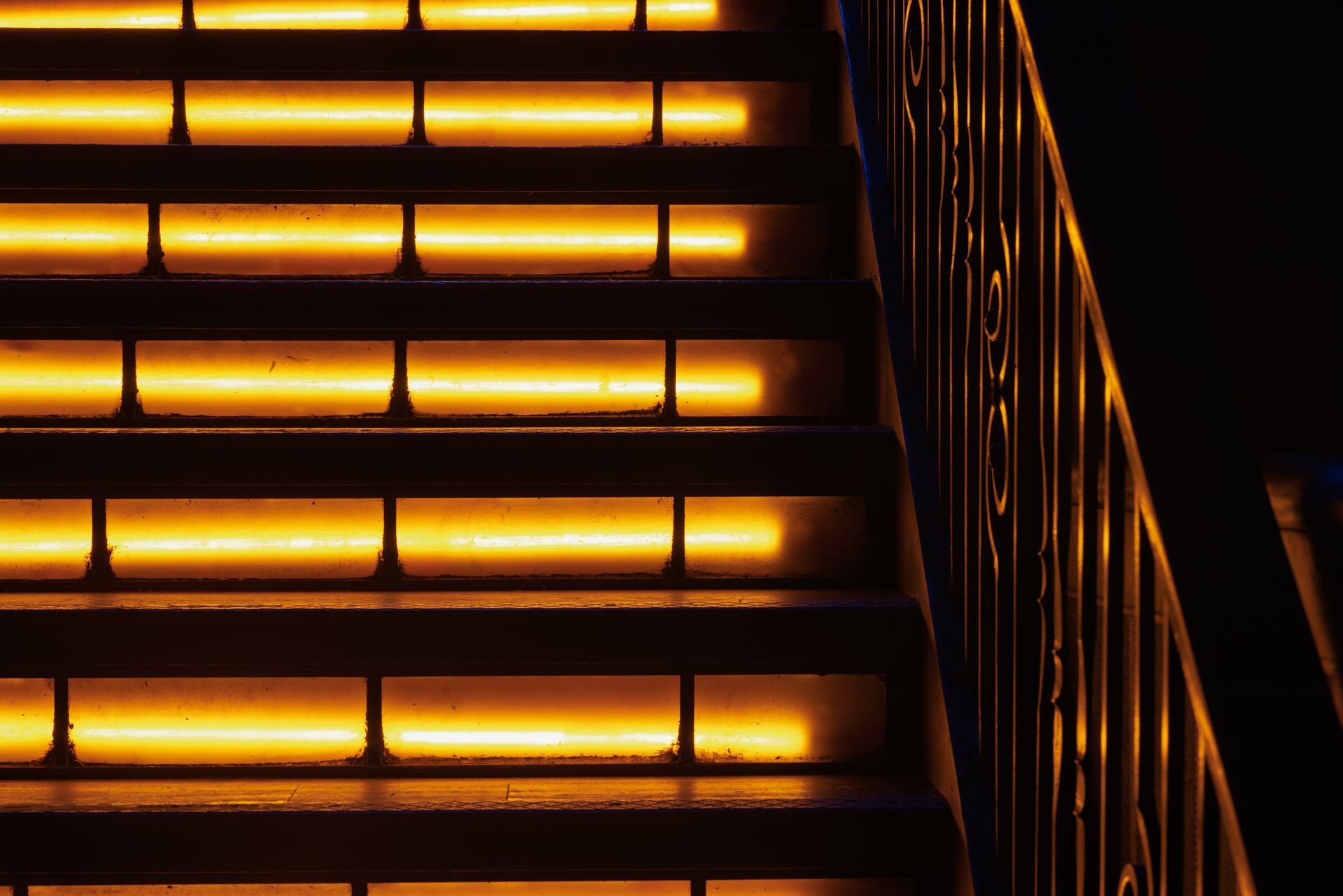 A close up of a set of stairs with lights on them at night.