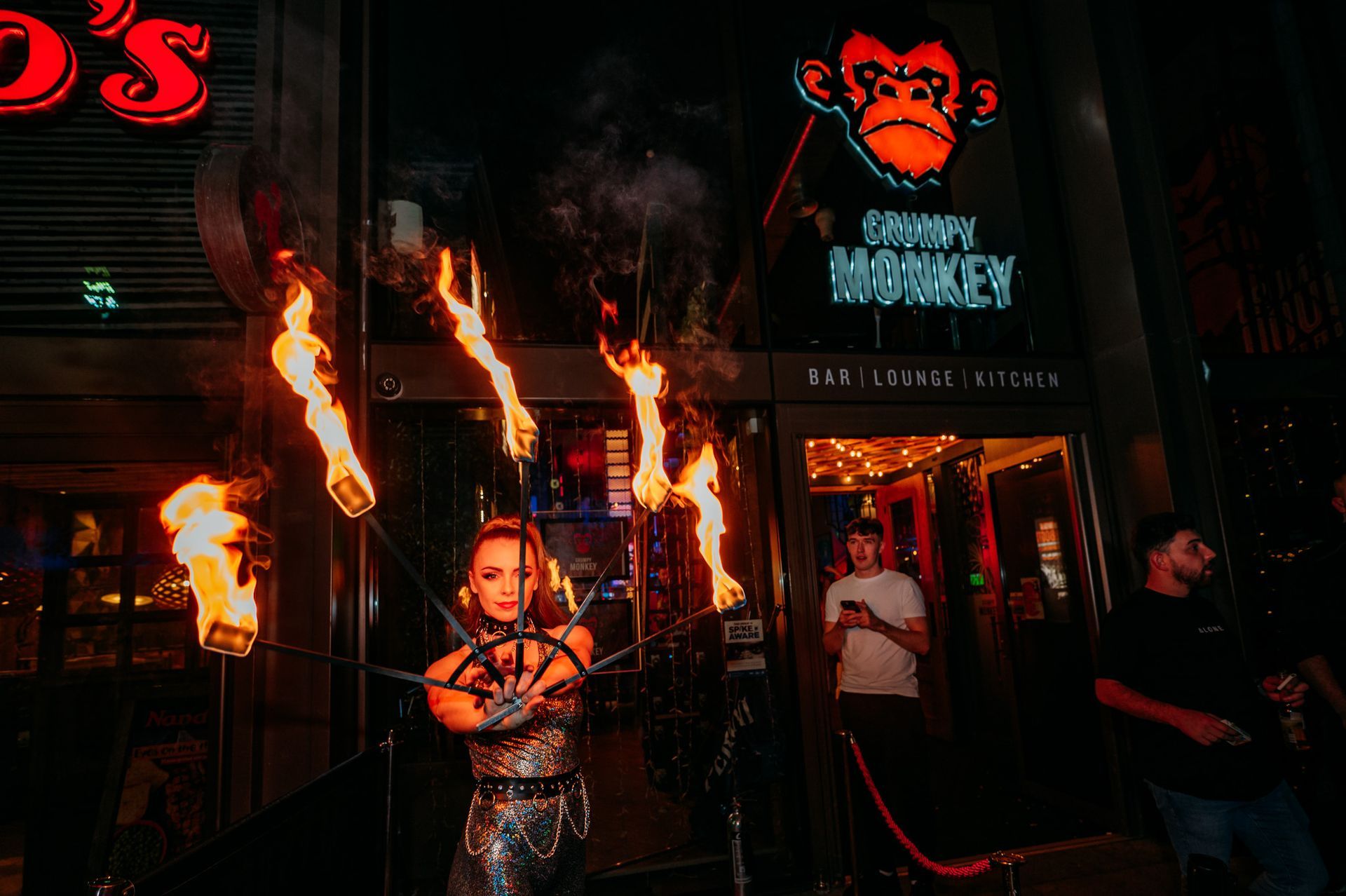 A woman is holding a torch in front of a groovy monkey restaurant.