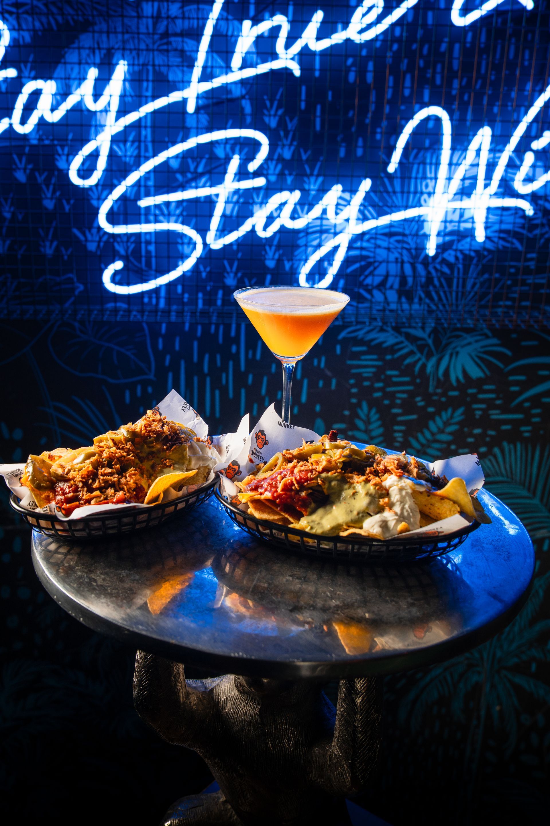 A table with two baskets of food and a martini on it.