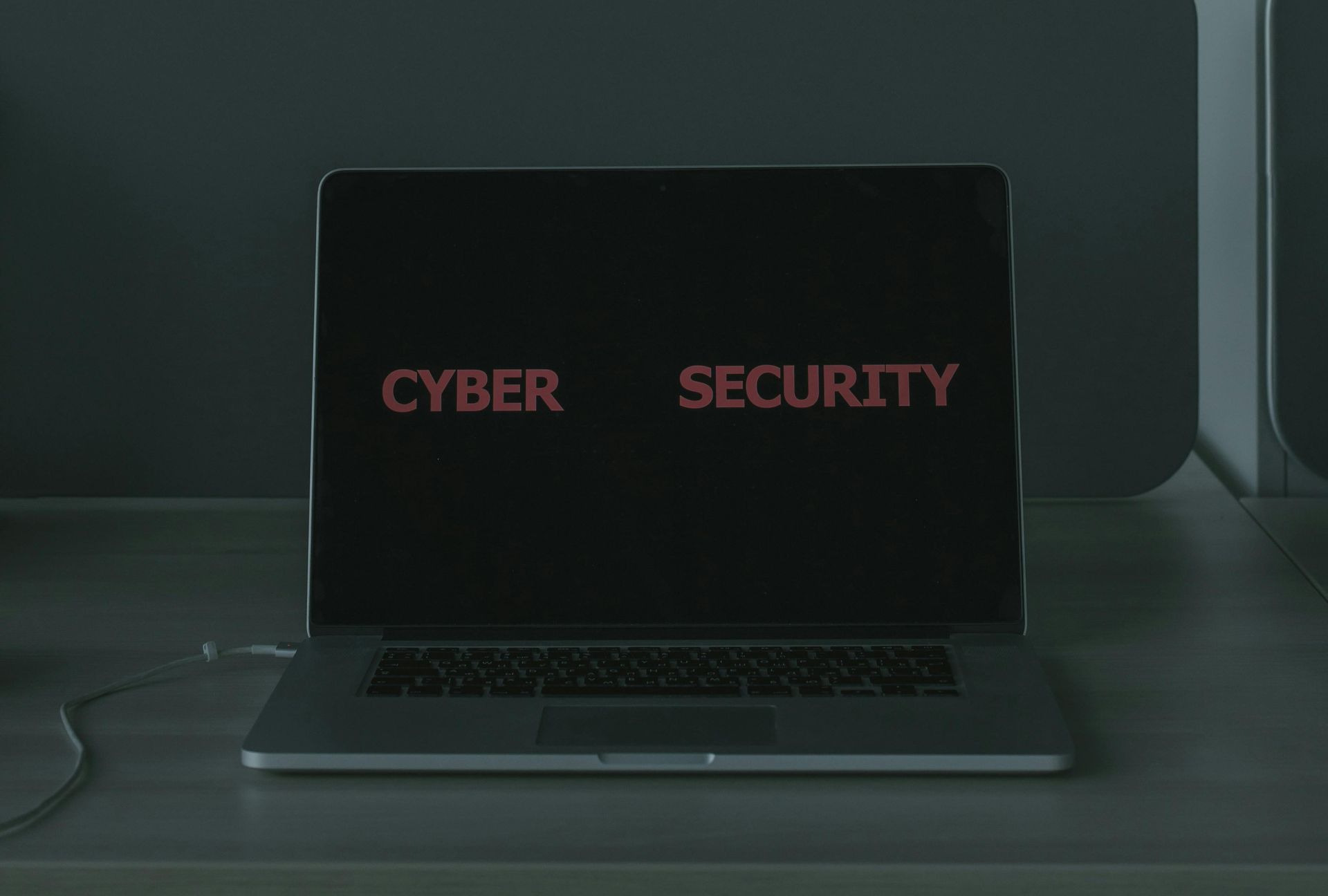 A laptop computer is open to a screen that says cyber security.