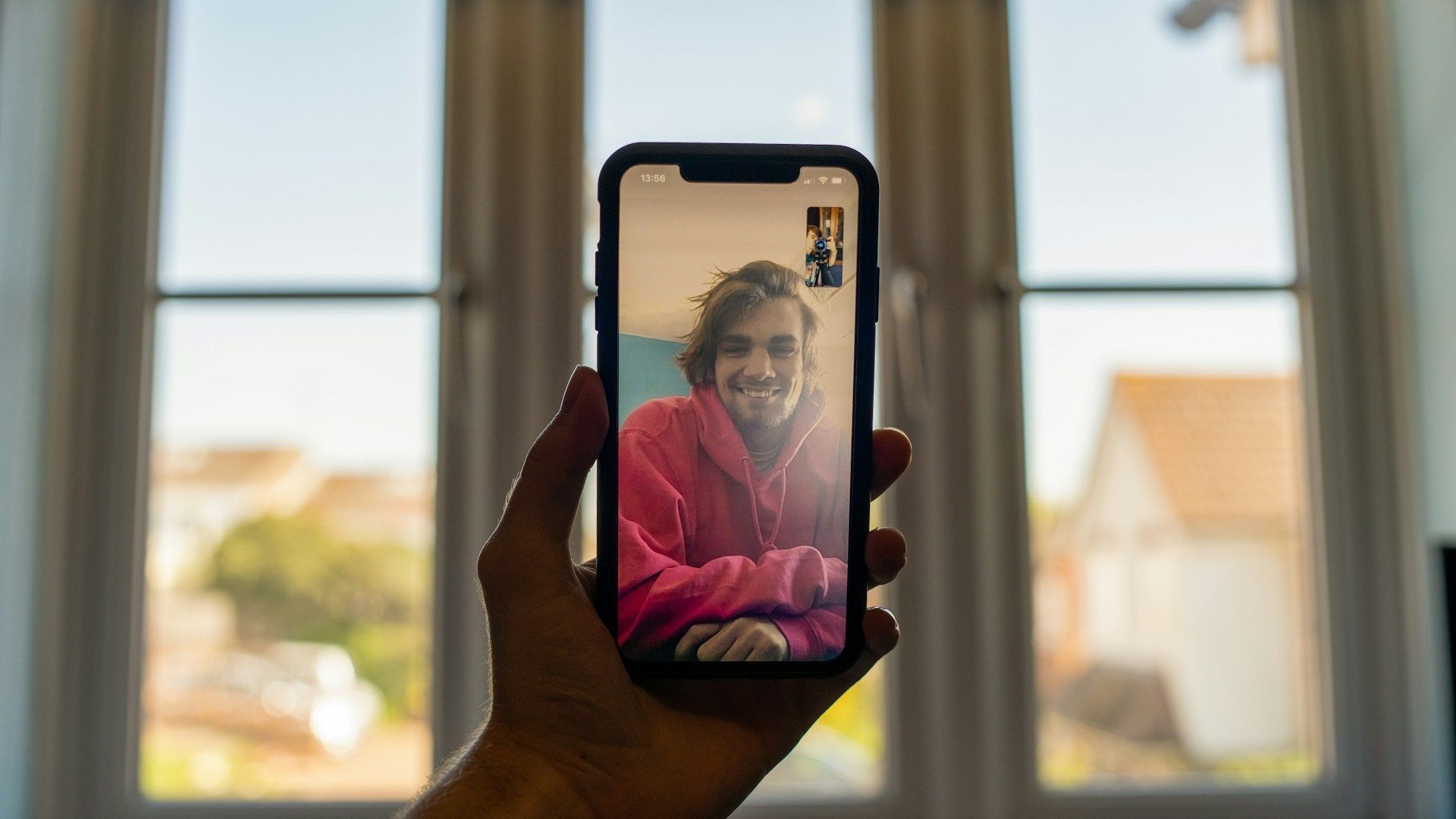 A person is holding a cell phone with a picture of a man on it.
