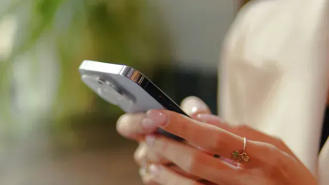 A woman is holding a cell phone in her hands.