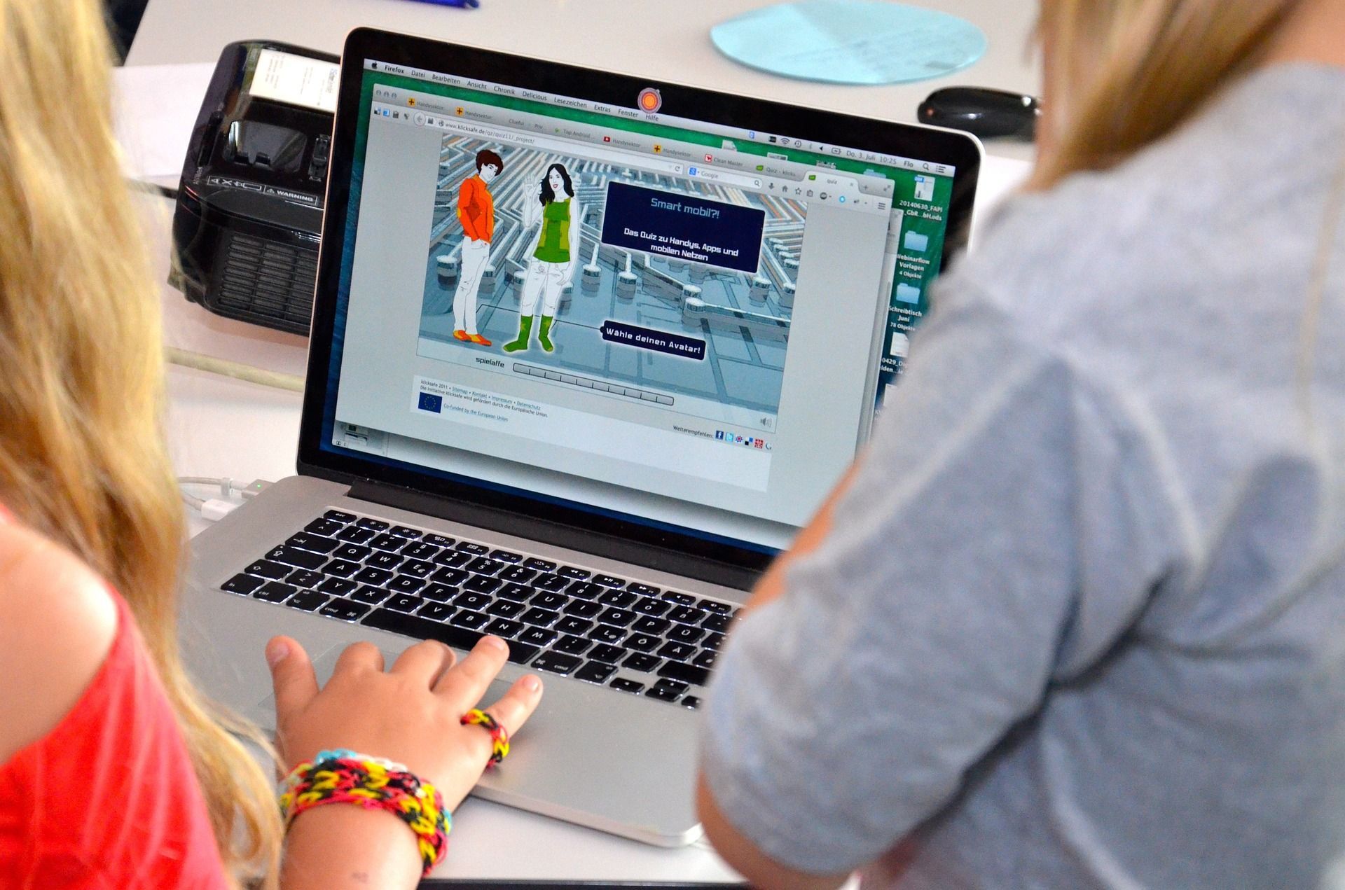 A woman is typing on a laptop with a picture on the screen