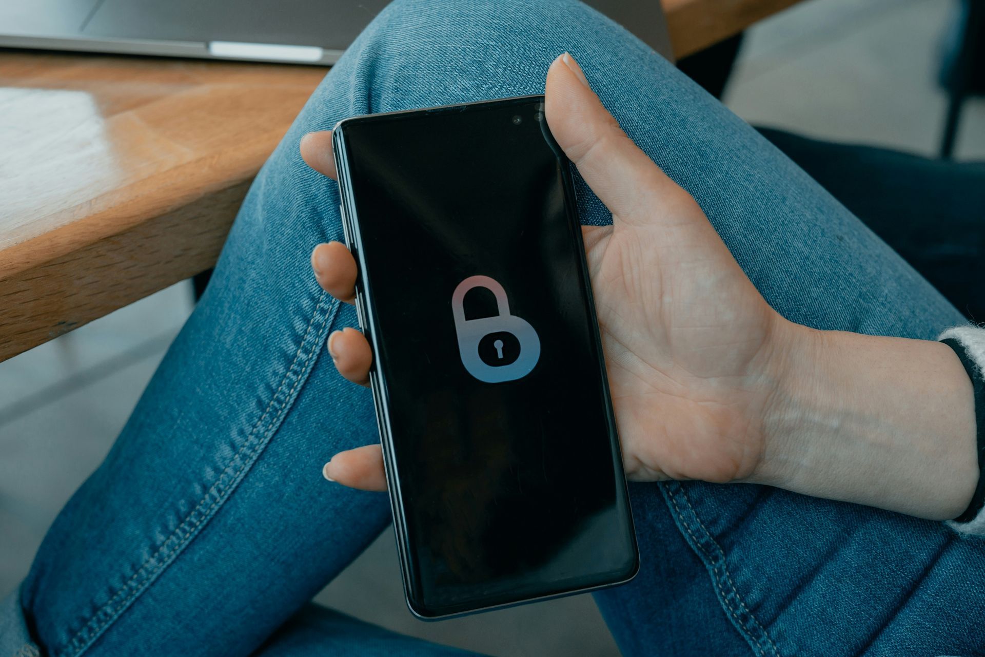 A person is holding a cell phone with a padlock on the screen.