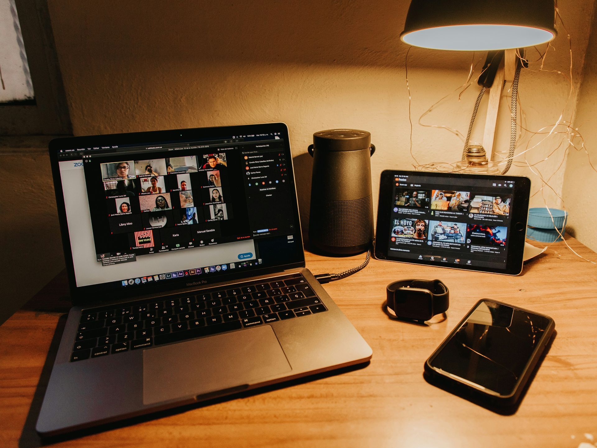 A laptop and a tablet are on a wooden desk