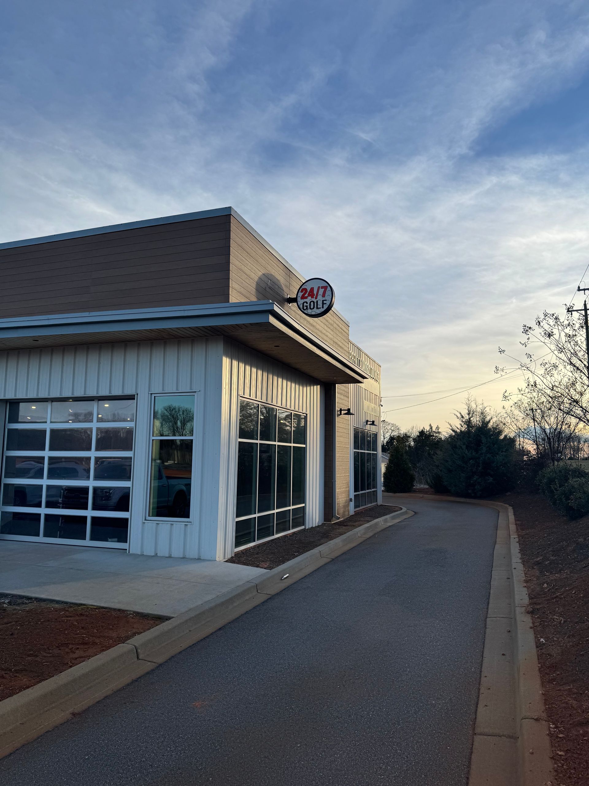 Indoor golf simulator with a screen displaying a golf course, green turf, and modern decor.