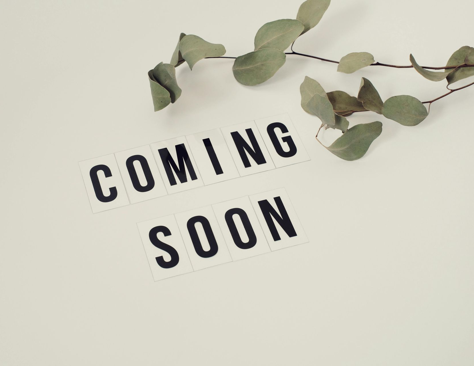 People playing cornhole on a rooftop patio with brick walls, green turf, and city views.