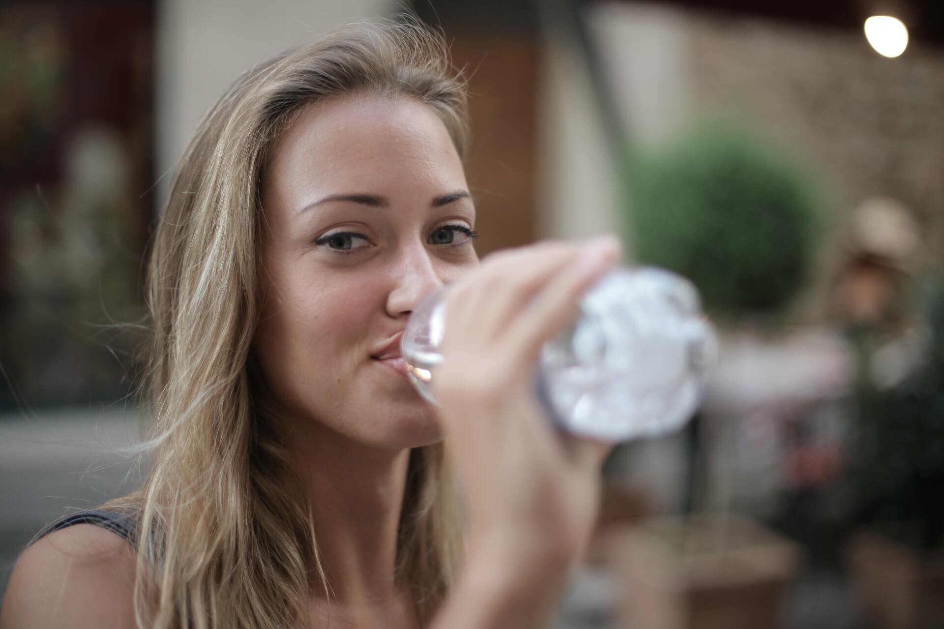 Jonge vrouw drinkt flesje water