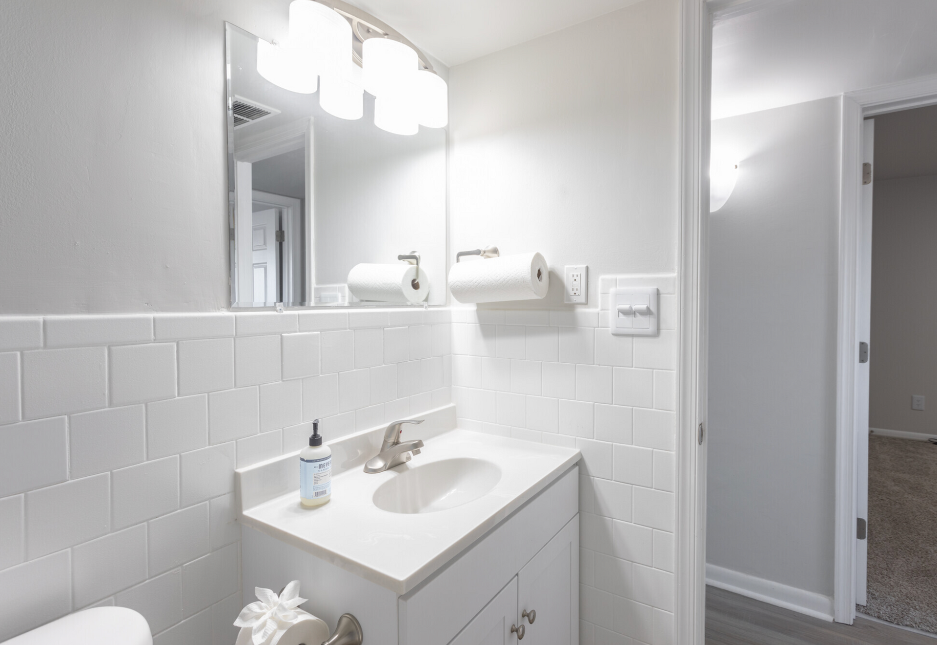 A bathroom with a sink , toilet and mirror.