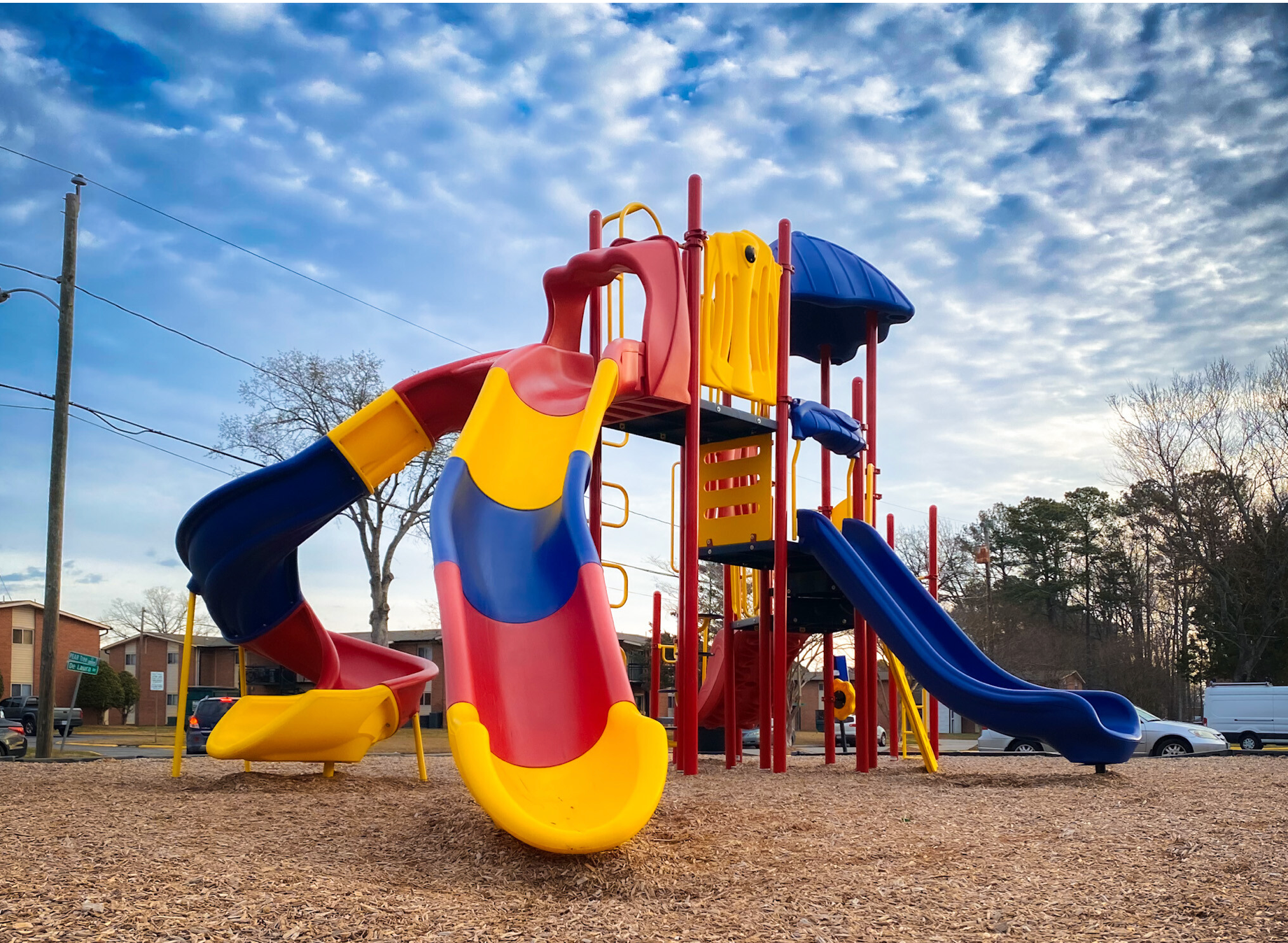 A colorful playground with a blue slide and a red slide
