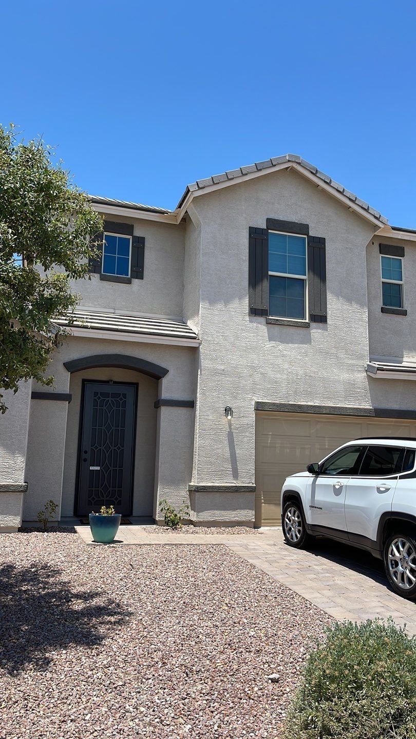 A white suv is parked in front of a large house.