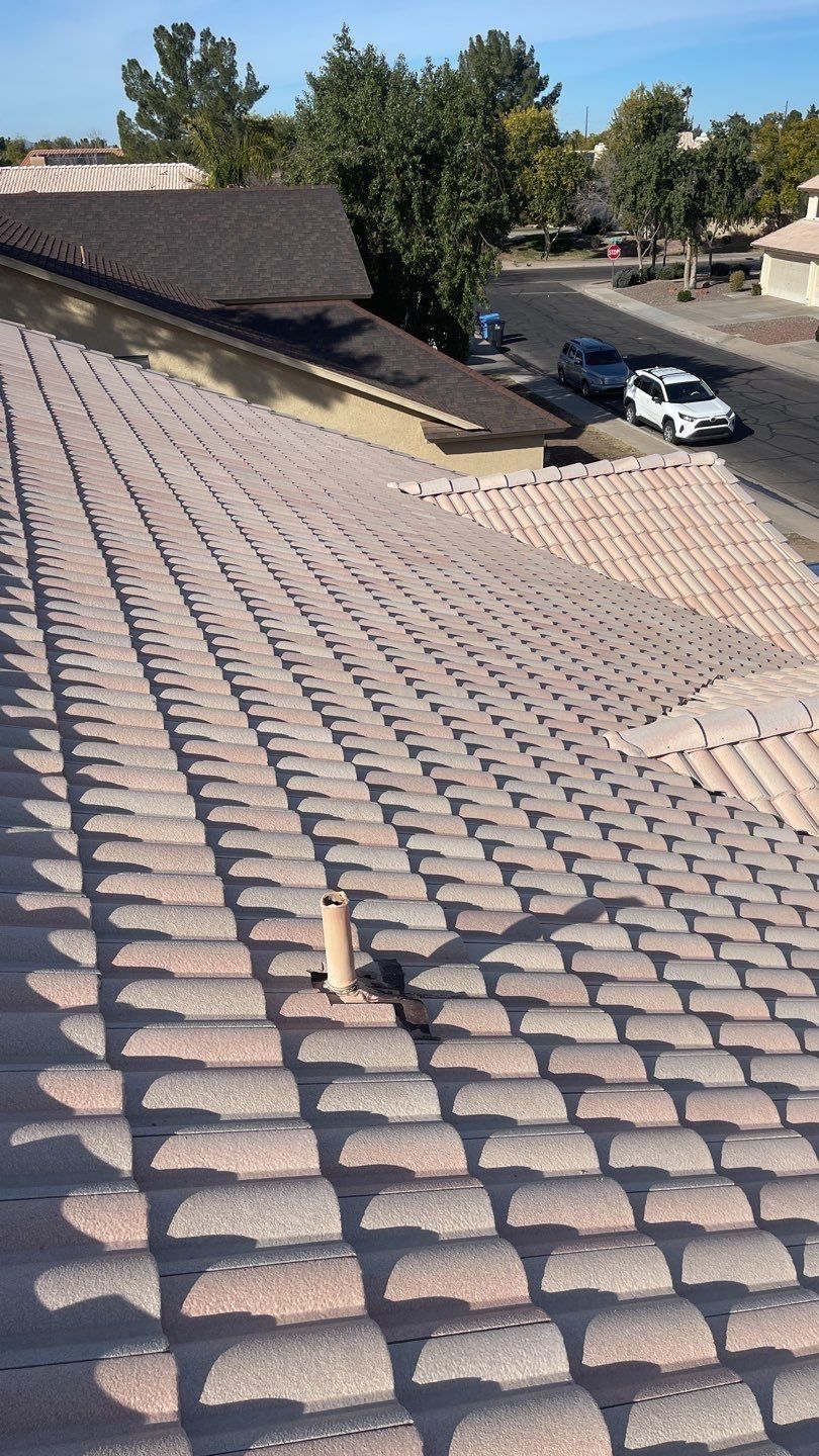A roof with a lot of tiles on it and a car parked on the side of the road.