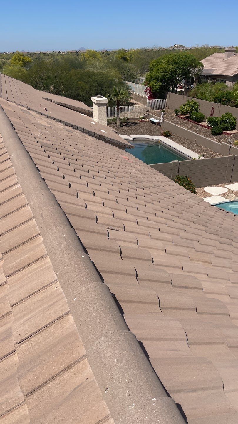 The roof of a house with a pool in the background.
