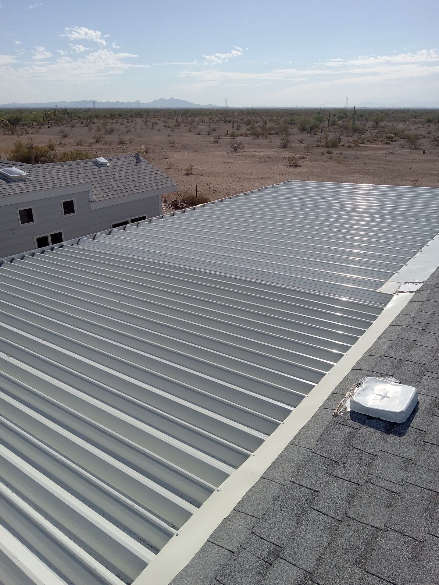An aerial view of a metal roof with a desert in the background.