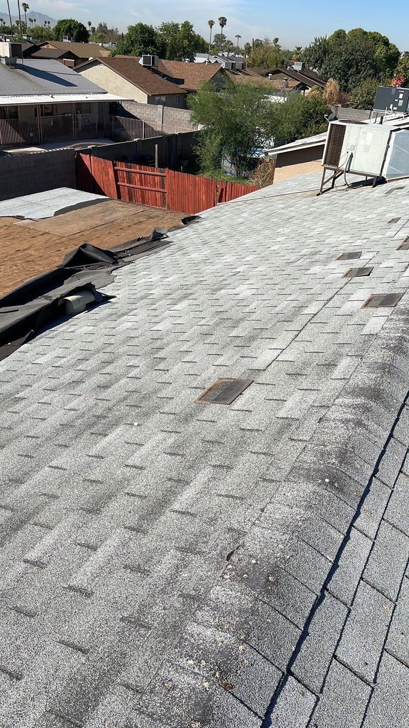 A close up of a roof with a red fence in the background.