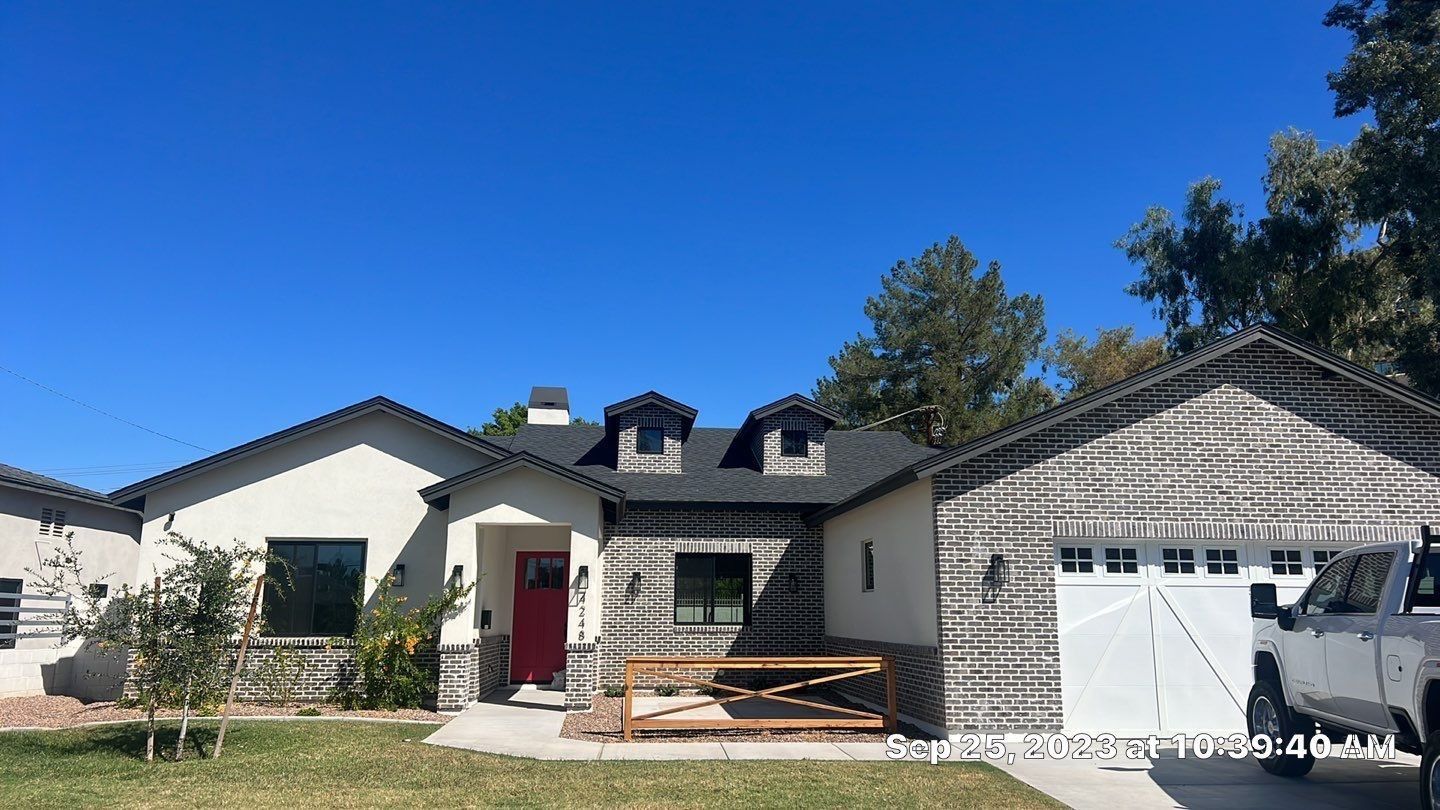 A white house with a red door and a white garage
