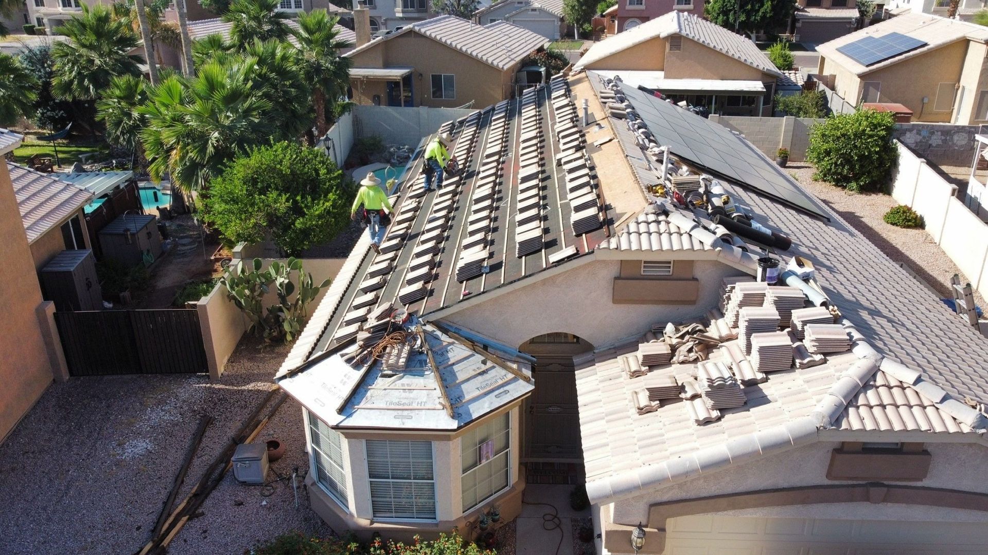 An aerial view of a house with a roof that is being repaired.