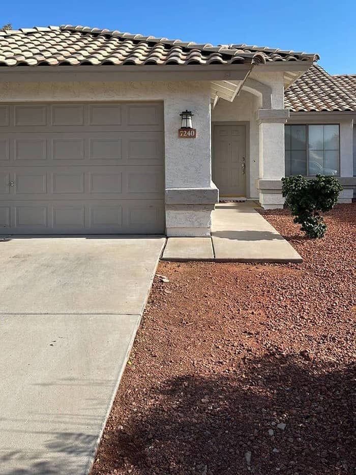 A house with a garage and a walkway in front of it.