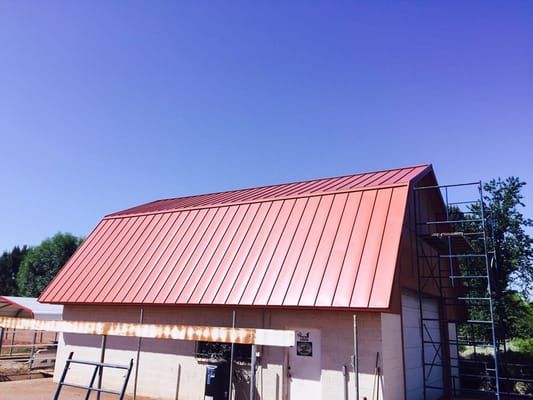 A barn with a red roof is under construction
