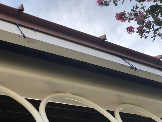 A close up of a roof with flowers in the background