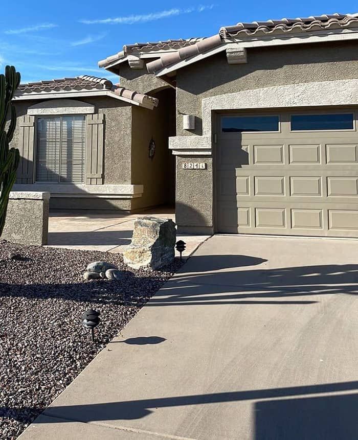 A house with a garage and a cactus in front of it