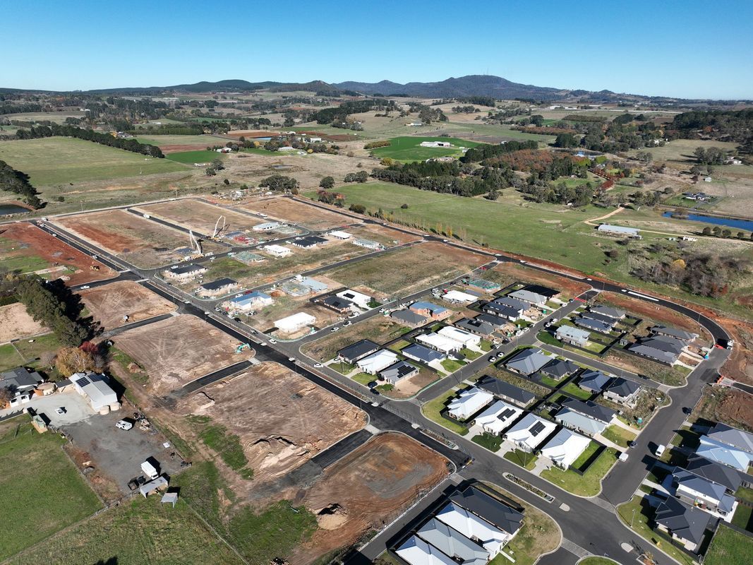 Aerial view of a newly developed suburban neighborhood. Houses are built, and land is prepared for construction.