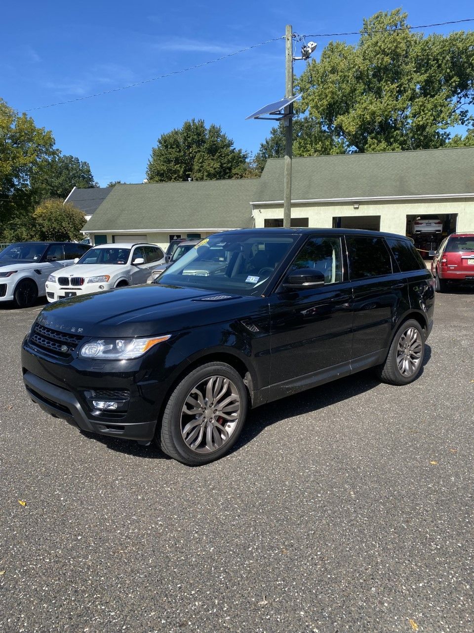 A black range rover sport is parked in a lot in front of a building. | InTown Auto Care