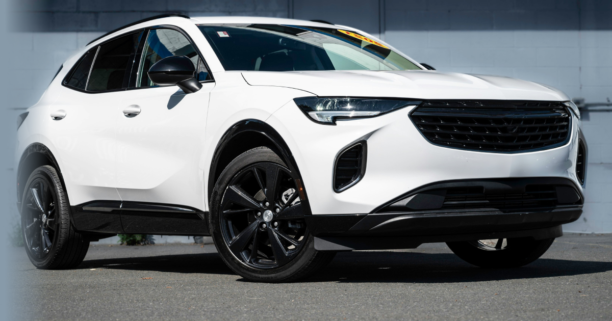 A white suv with black wheels is parked in front of a building. | InTown Auto Care