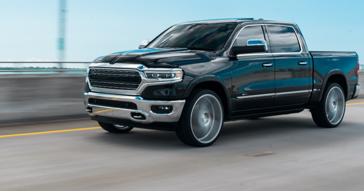 A black ram truck is driving down a highway. | InTown Auto Care