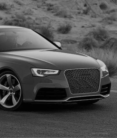 A black and white photo of an audi a5 driving down a road. | InTown Auto Care