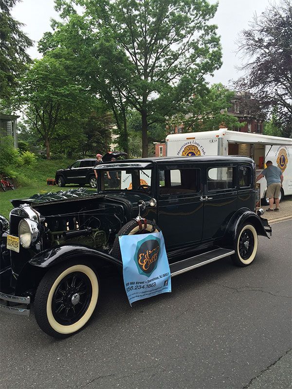 An old black car is parked on the side of the road. | InTown Auto Care